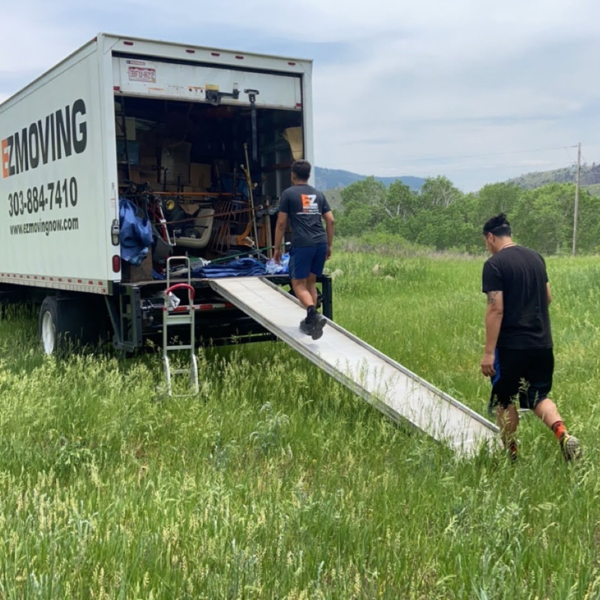 EZ Moving Team Loading truck in pasture