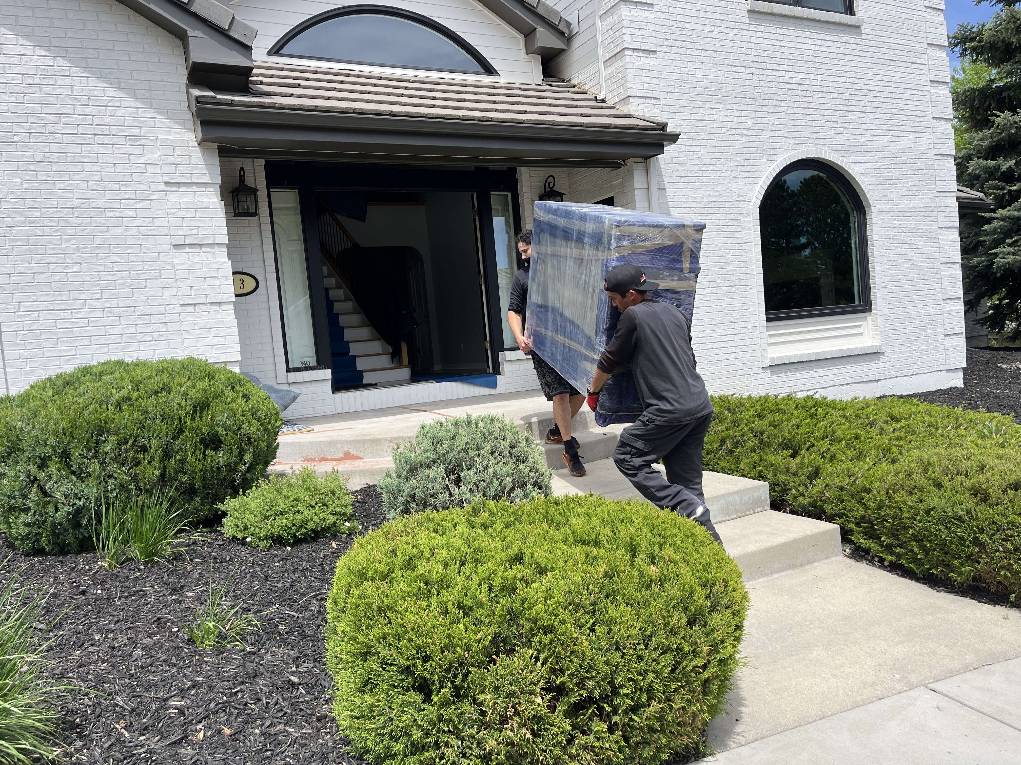 EZ Movers carrying heavy furniture through a doorway