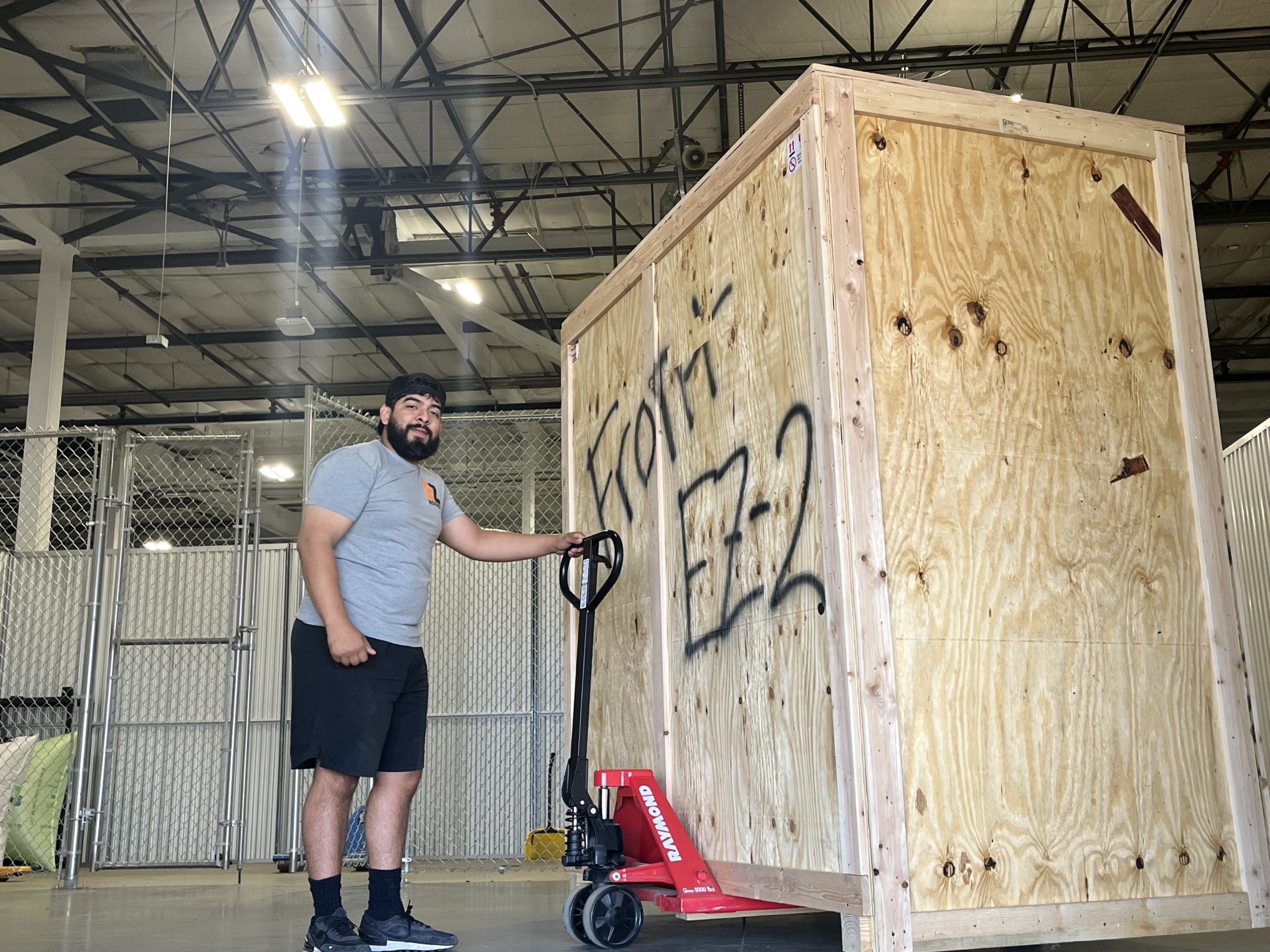 EZ Moving Manager pushing wood storage crate through storage facility