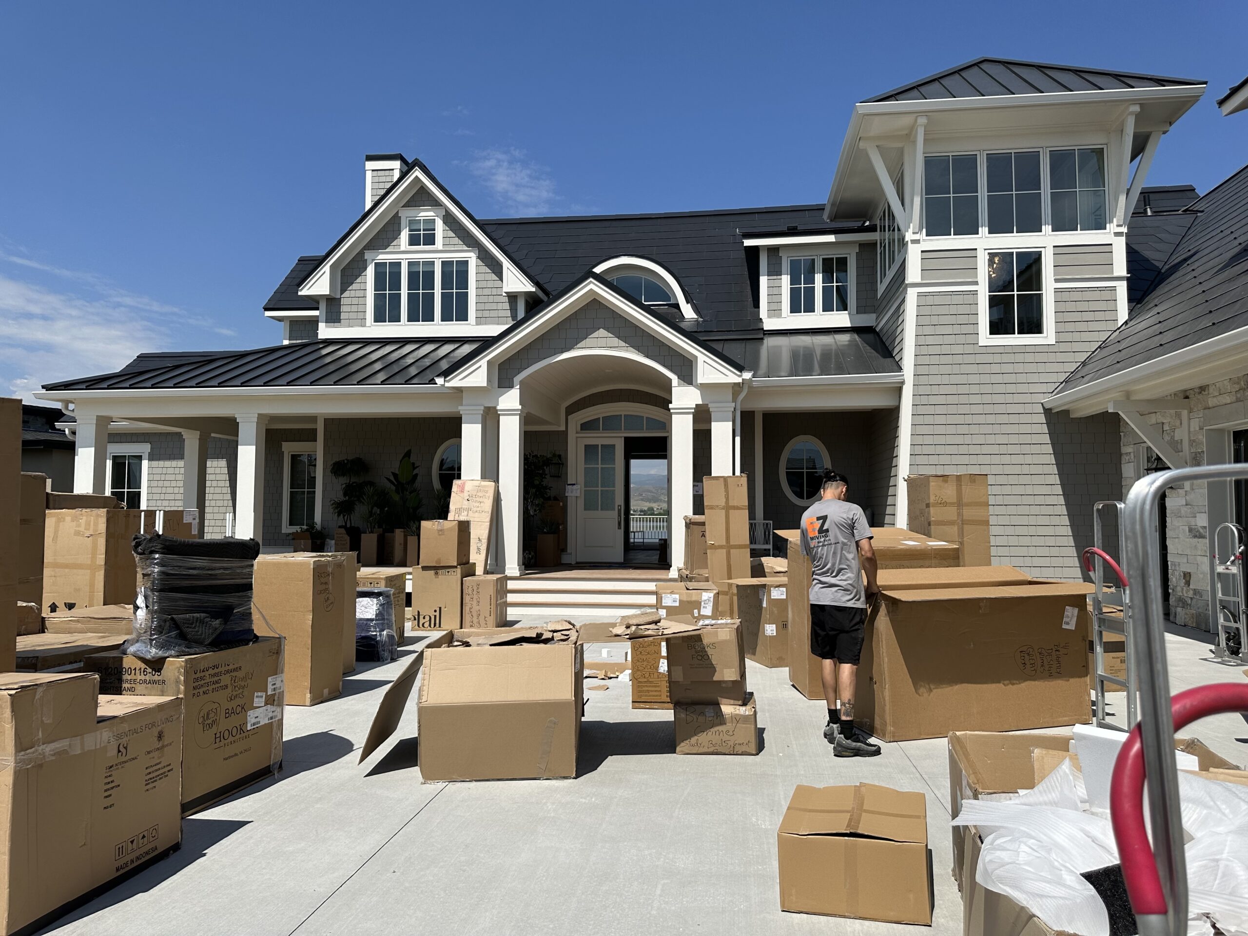 Many moving boxes sitting in the driveway of a house