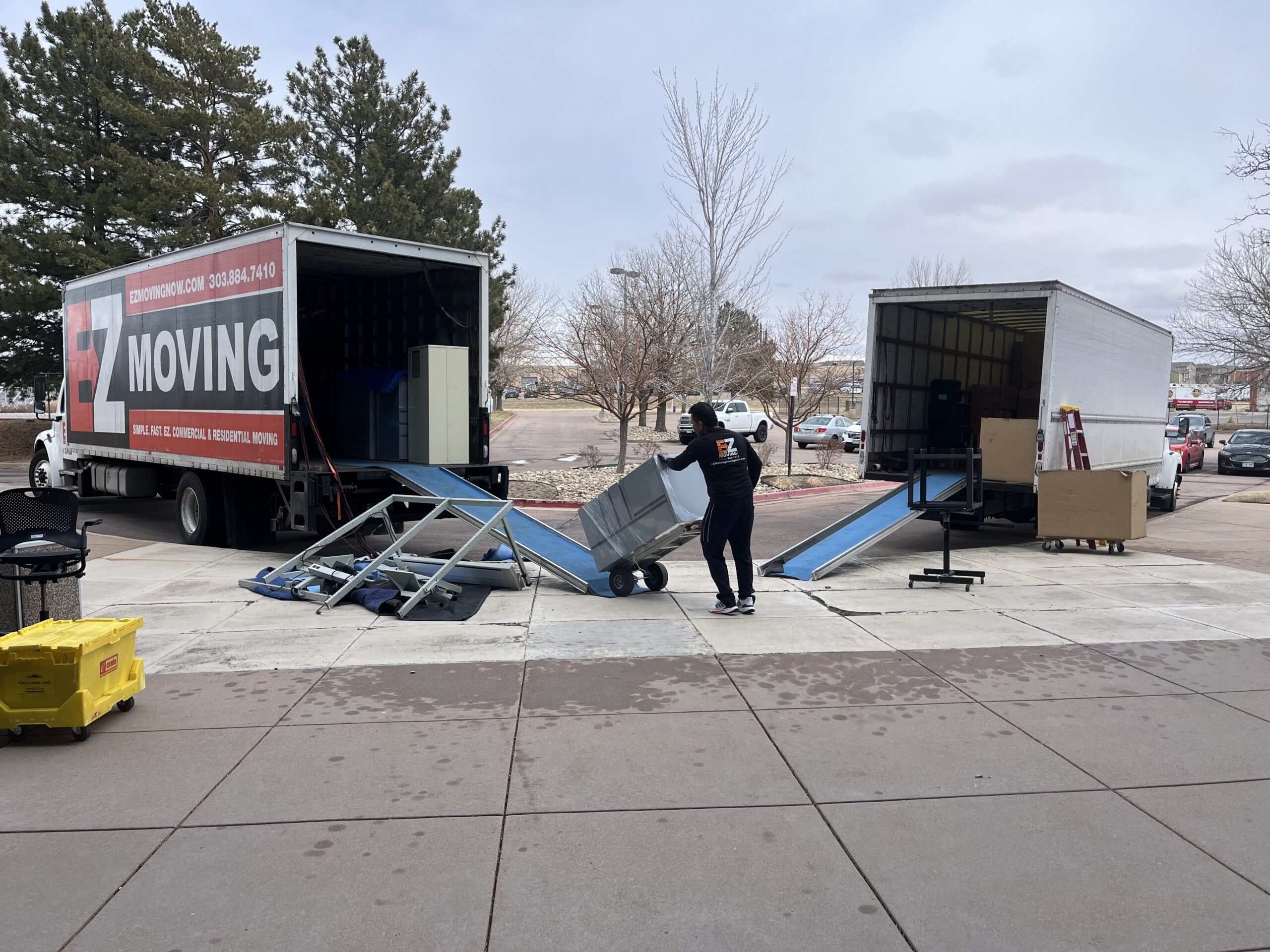 Two EZ Moving trucks parked outside of office building for a commercial move