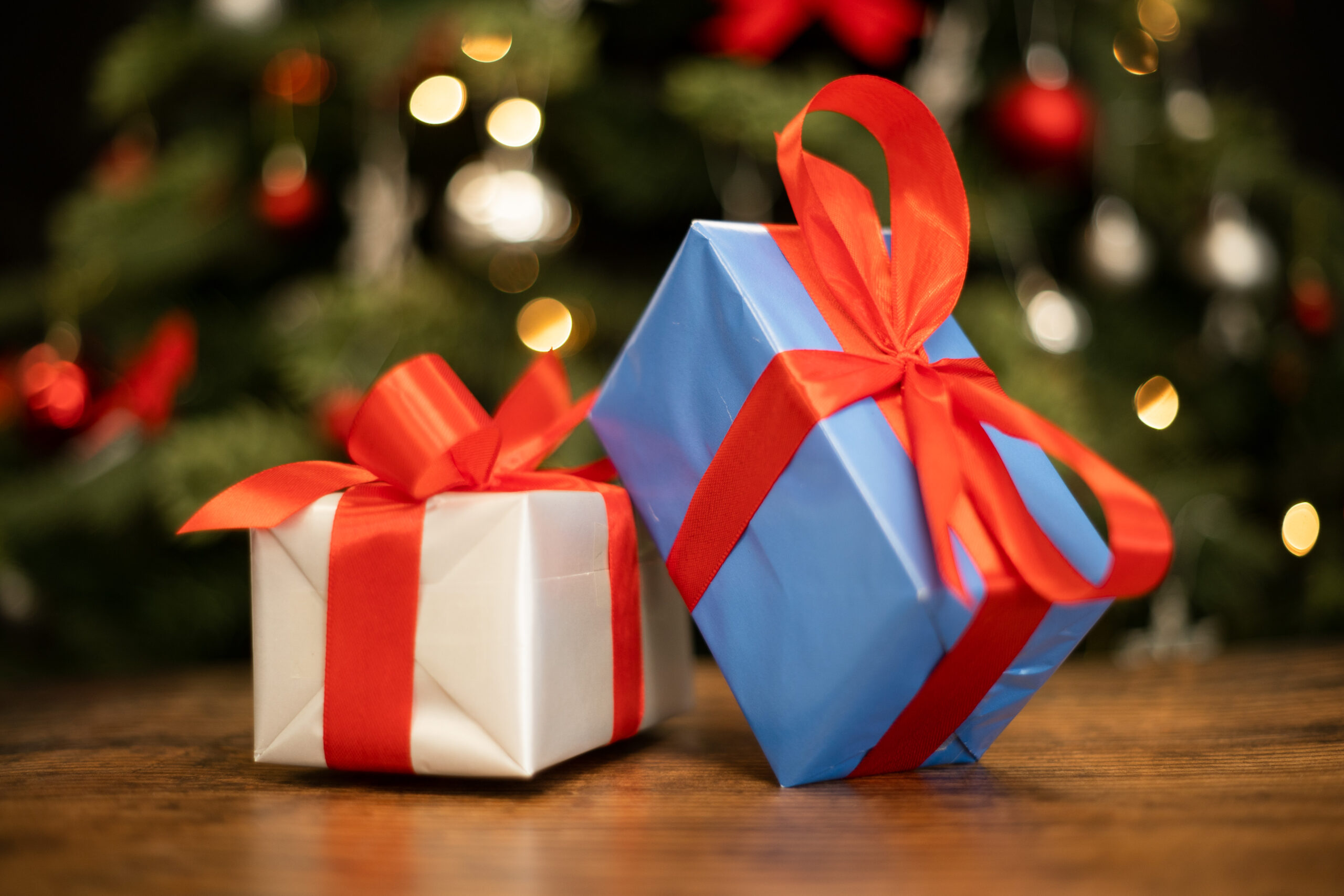 Christmas presents on a table in front of christmas tree